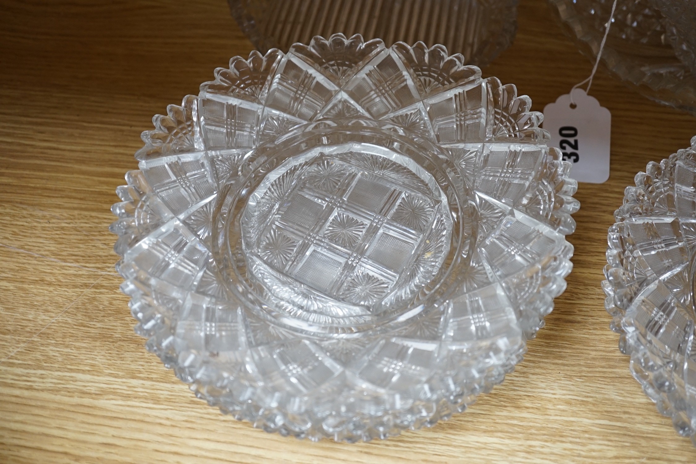 Eight 19th century cut glass circular plates probably Irish, a similar octagonal dish, a later oval cut glass dish and a similar punch bowl, bowl 26 cms diameter